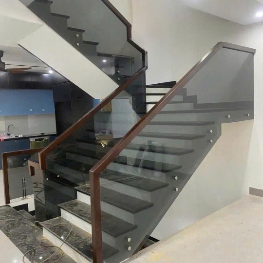 Cầu thang kính màu xám khói tay vịn gỗ